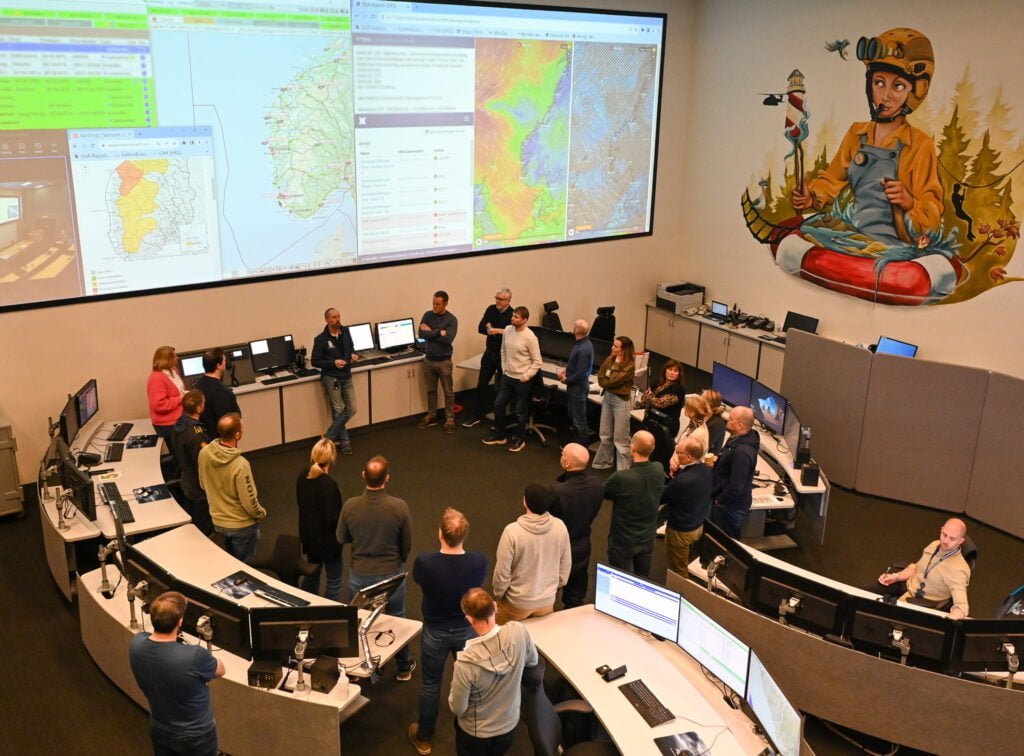 En gruppe mennesker er på besøk i operasjonsrommet til HRS på Sola