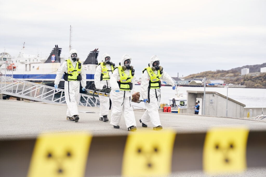 Et team i verneutstyr bærer en person på båre. 