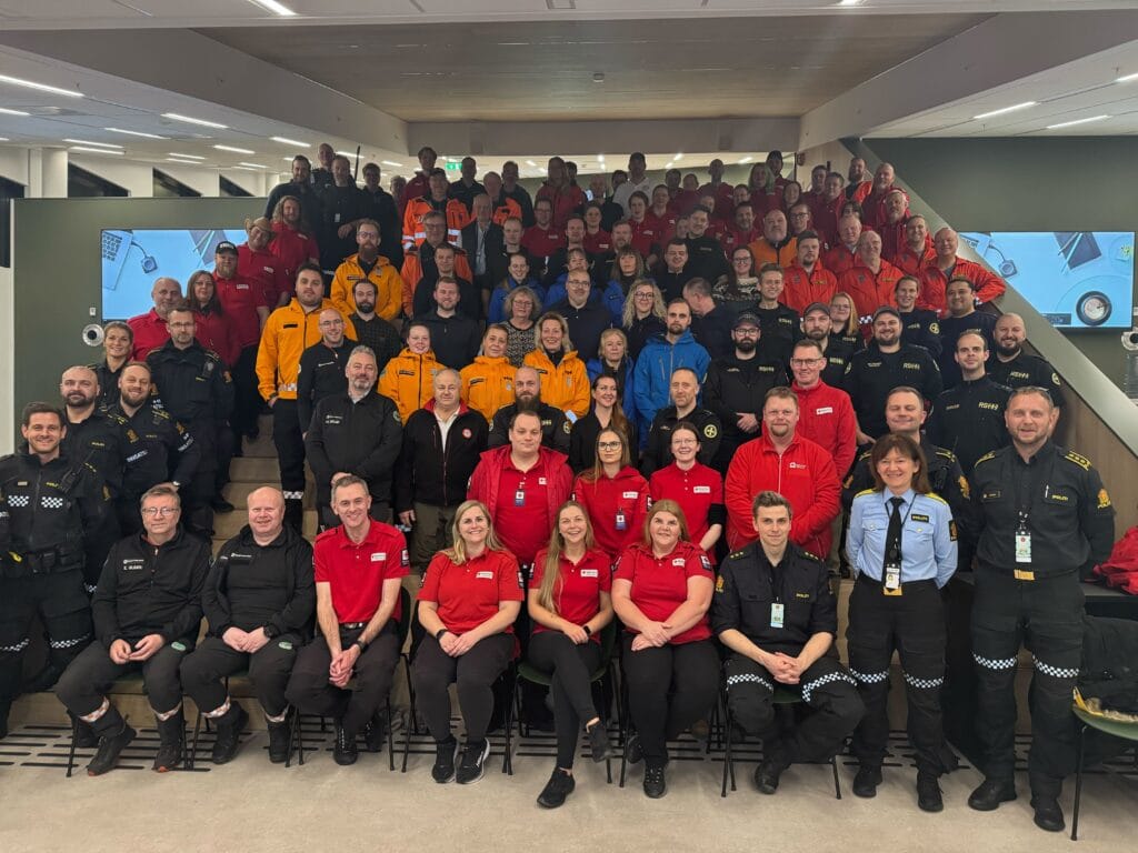 Gruppefoto av av en stor gruppe mennesker, frivillige og politi innendørs på politistasjonen i Kristiansand.