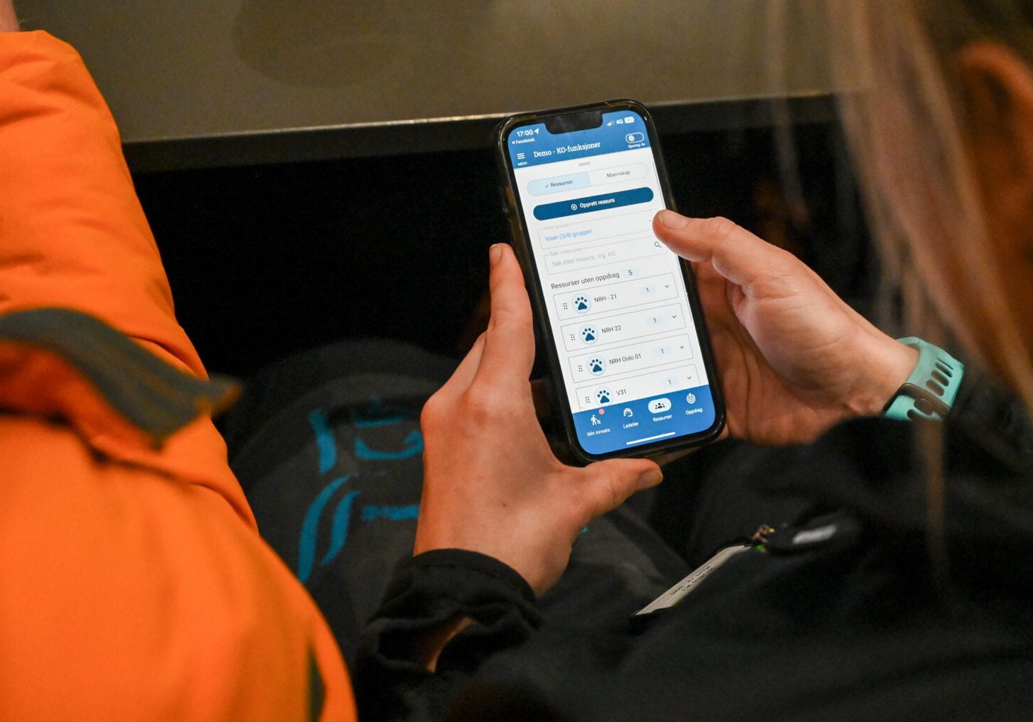 En kvinne holder en mobiltelefon og man ser demonstrasjon av et støtteverktøy på mobilen.