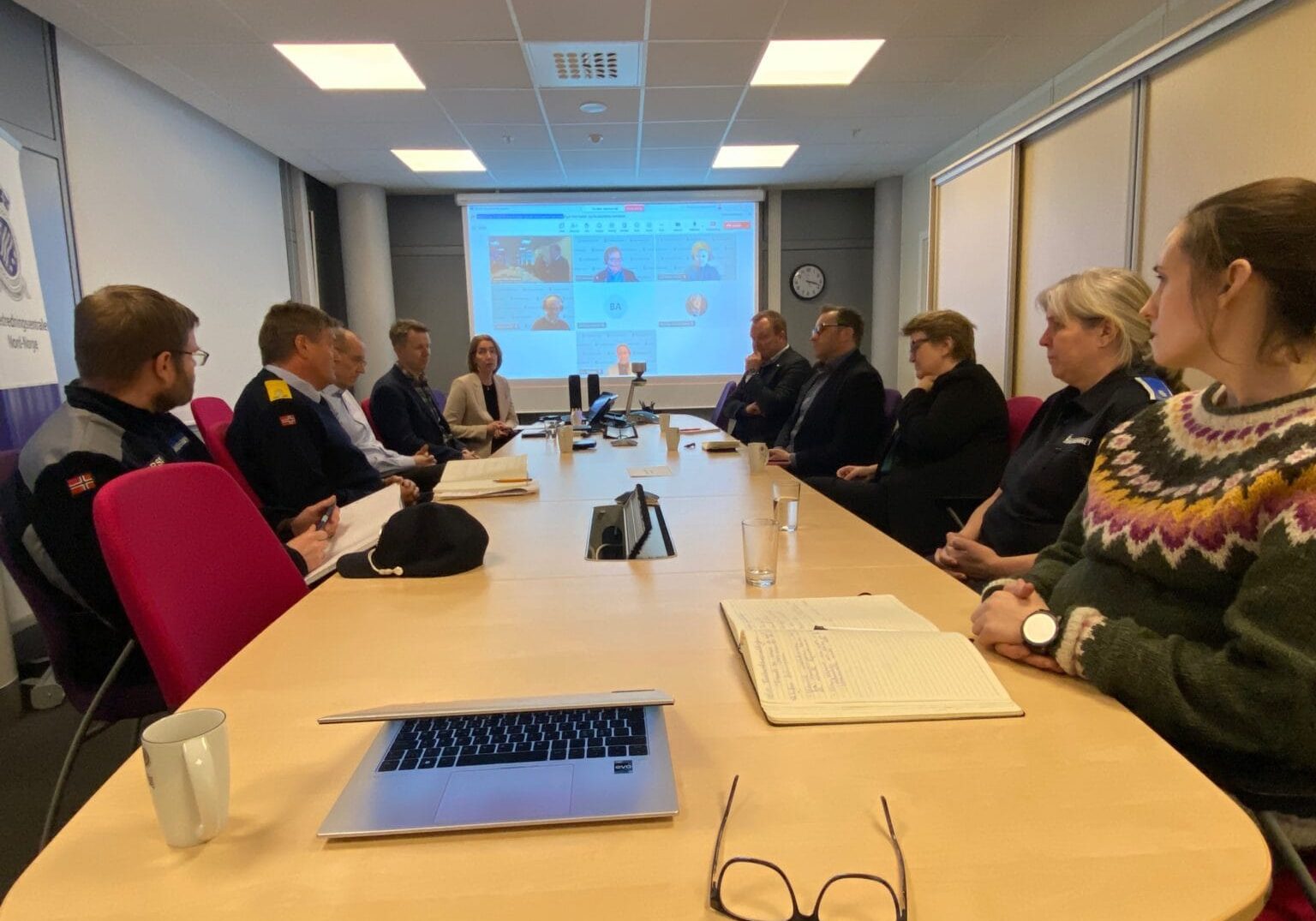 Mennesker sitter rundt et møtebord.