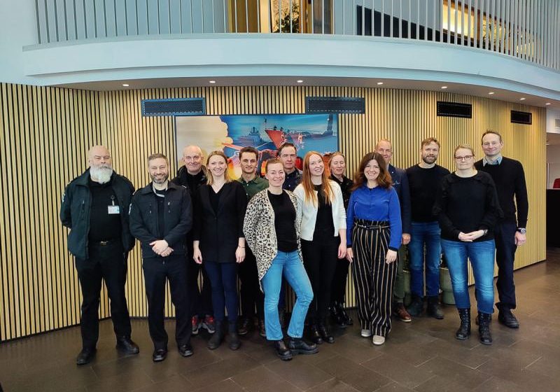 Gruppebildet av mennesker som ser i kamera