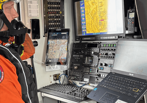 Mann i helikopter ser på dataskjerm