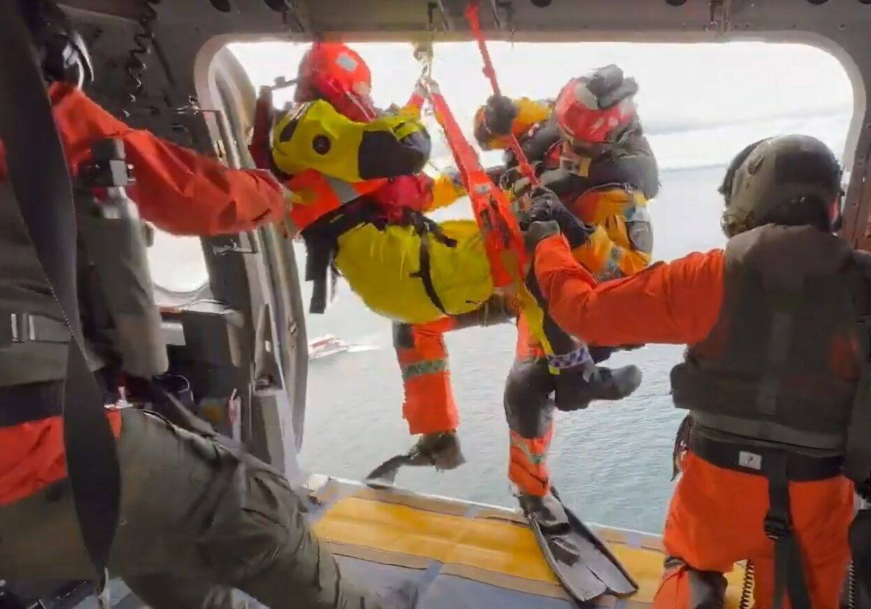 Person tas om bord i redningshelikopter etter å ha blitt heist opp fra sjøen